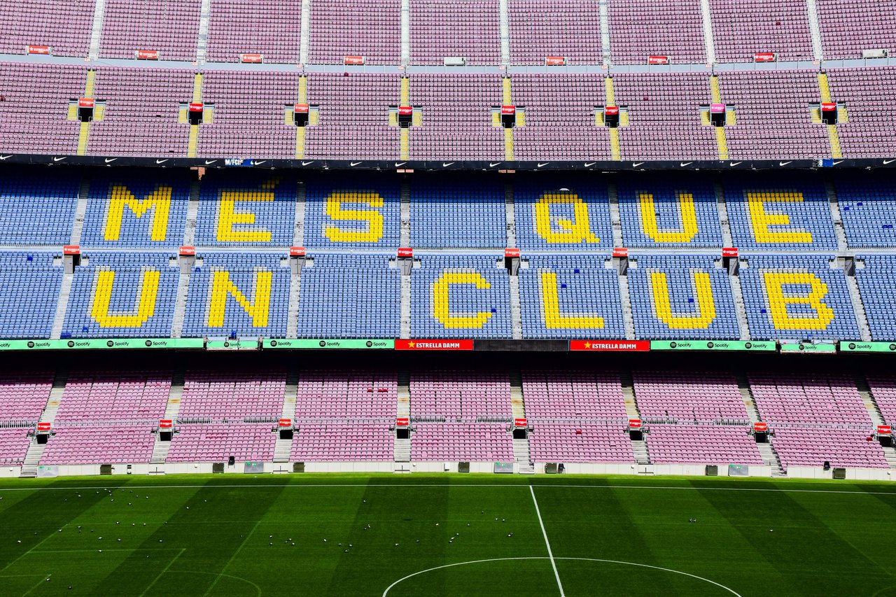 Estádio Camp Nou com o slogan “Més que un club” visível nas arquibancadas.