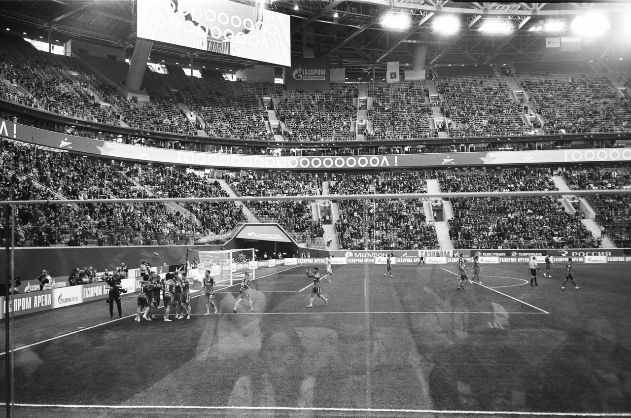 Jogadores de futebol se abraçam e se parabenizam após uma vitória em um estádio lotado.